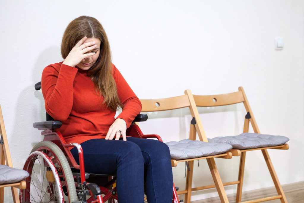 Frau sitzt im Rollstuhl
